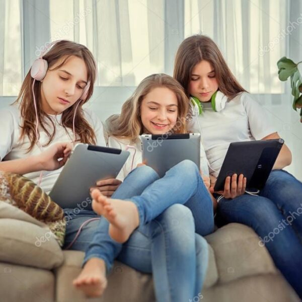 Teenage girls with tablet pc computer and headphones listening music and communicate in social networks