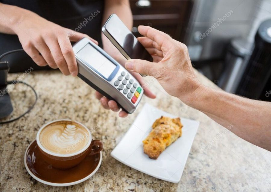 Customer Paying Through Mobilephone Over Electronic Reader At Ca