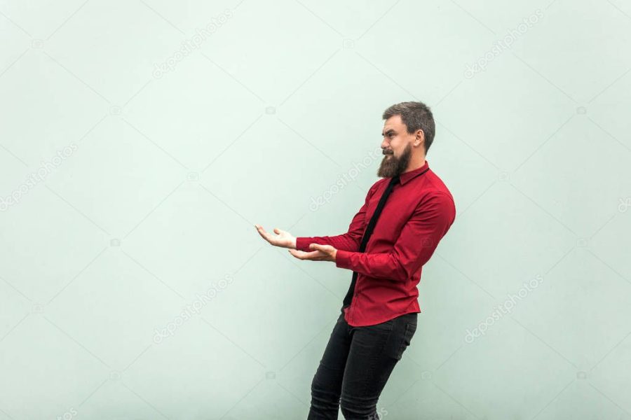 Bearded man in casual clothes, keeps something heavy