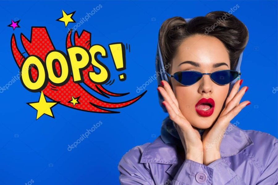 portrait of stylish woman in retro clothing and sunglasses with comic style oops sign isolated on blue
