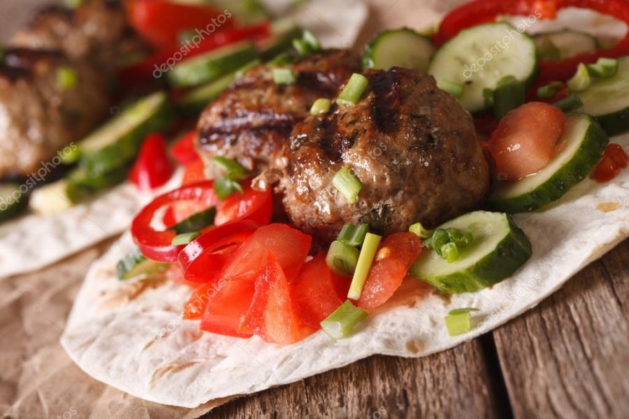 Meatballs with fresh vegetables on a tortilla close-up. horizont