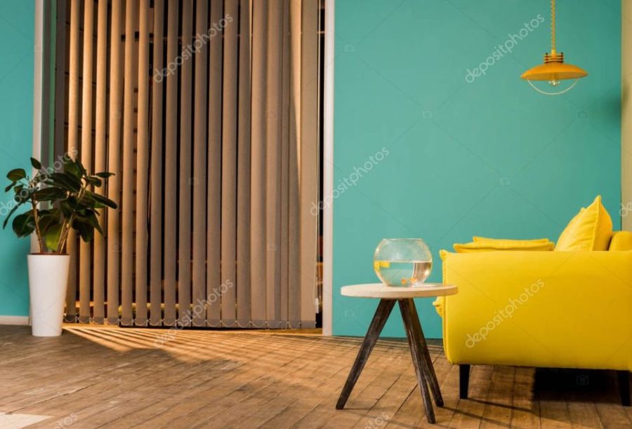 yellow sofa and aquarium with fish on table in living room