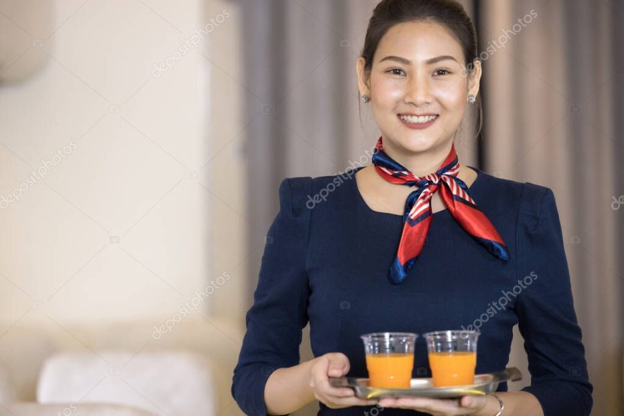 Cabin crew serve water to passenger in airplane . Airline transportation and tourism concept.