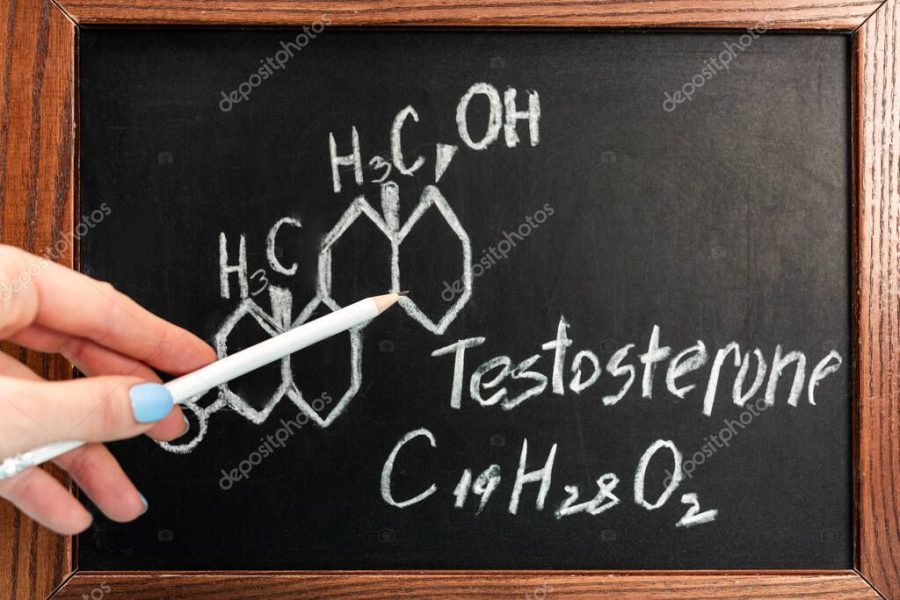 Cropped view of woman holding pencil near blackboard with testosterone formula