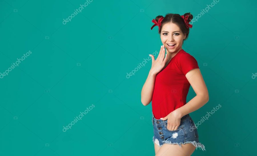 Fashionable pinup girl in red shirt at blue background