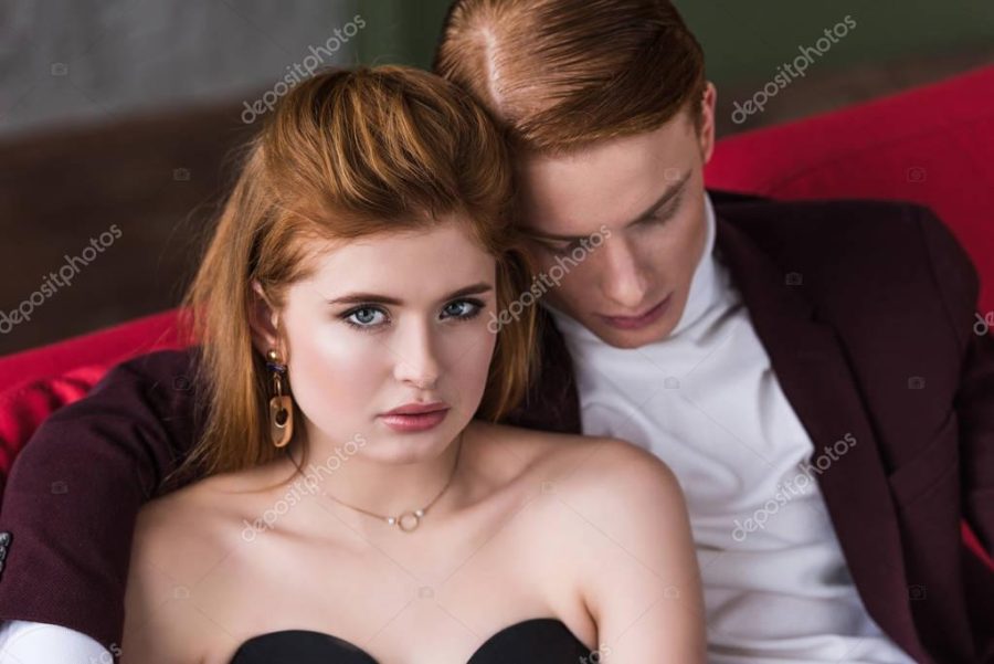Female fashion model with earrings and necklace lying on boyfriend should