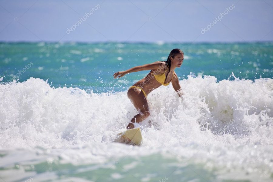 Girl in a yellow bikini surfing