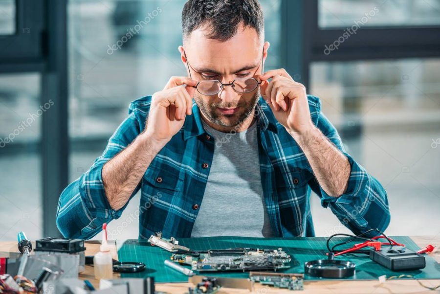 Hardware engineer in glasses working with pc parts