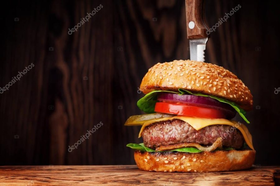 Tasty grilled burger with beef, tomato, cheese, cucumber and lettuce. With copy space