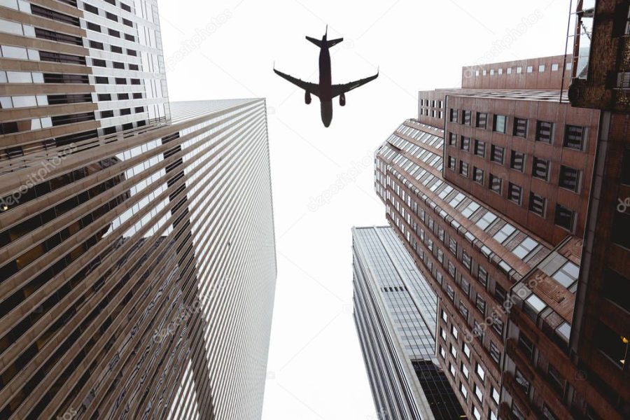 bottom view of skyscrapers and clear sky with airplane in new york city, usa
