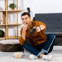 emotional man eating popcorn while playing video game