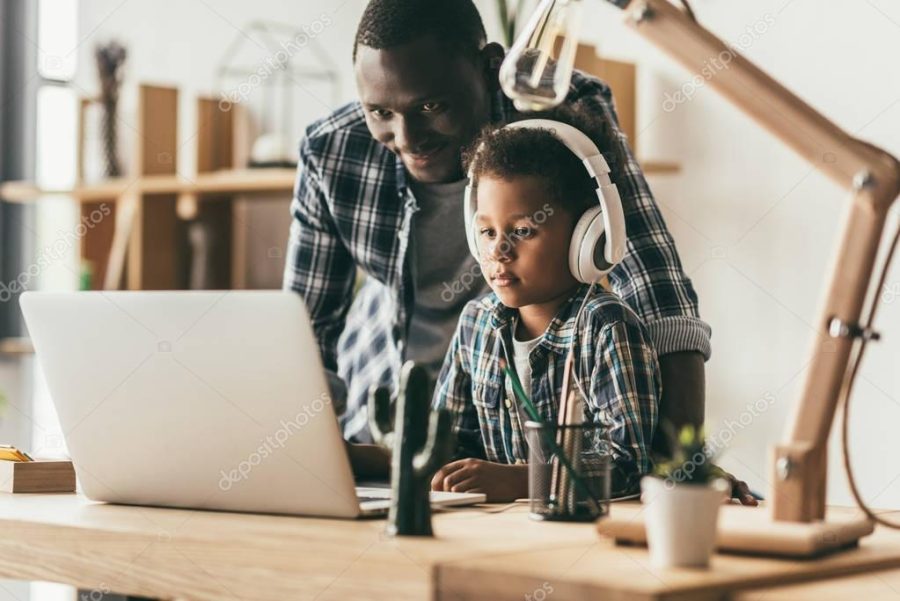 father and son using laptop