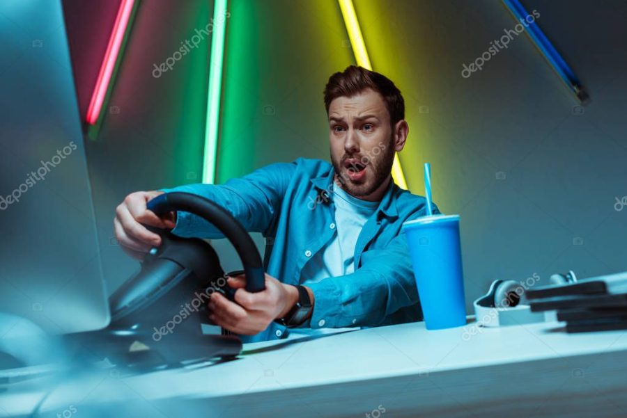 handsome and good-looking man playing video game with steering wheel