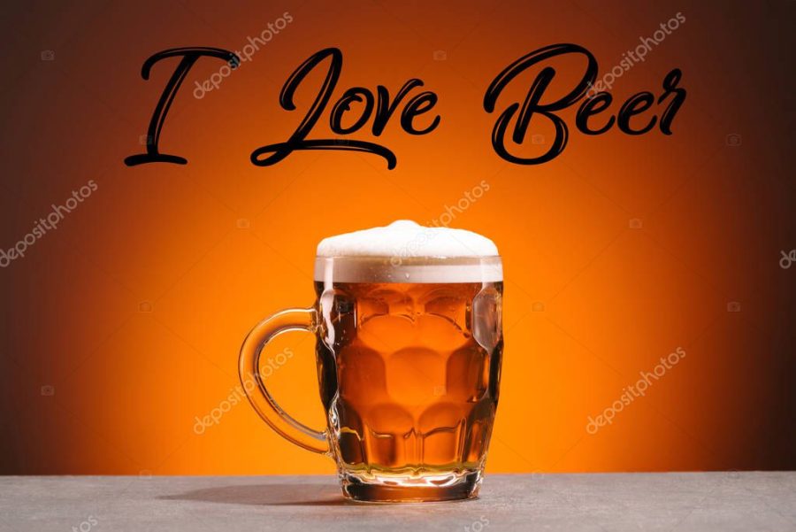 close up view of mug of cold beer and i love beer lettering on orange backdrop
