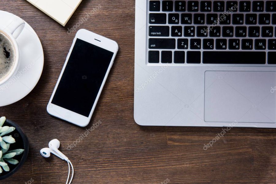 Coffee cup and smartphone on desk