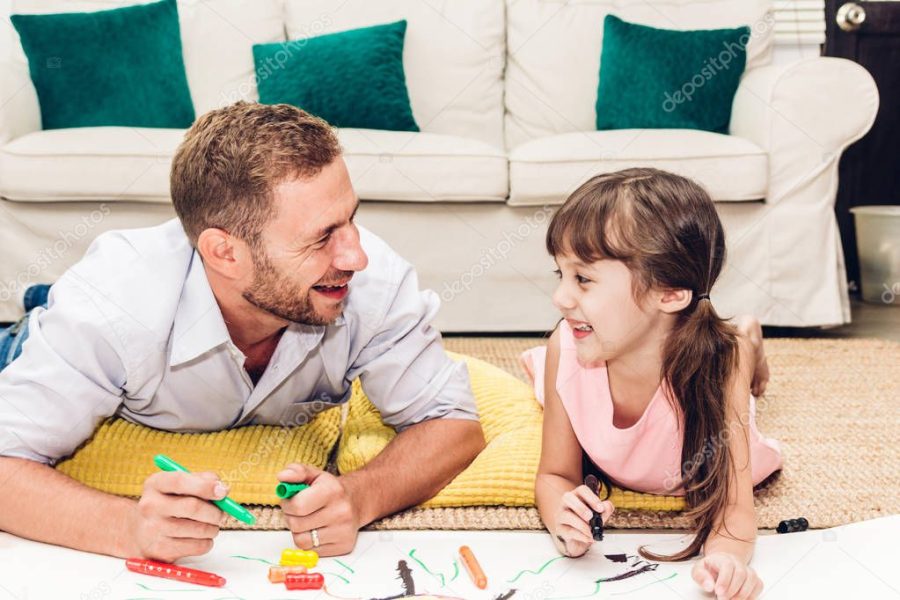 Father with little daughter having fun and do her homework at home.painting and drawing.Love of family and father day concept