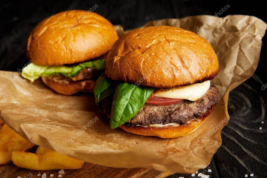 Hot burgers and french fries served on craft paper