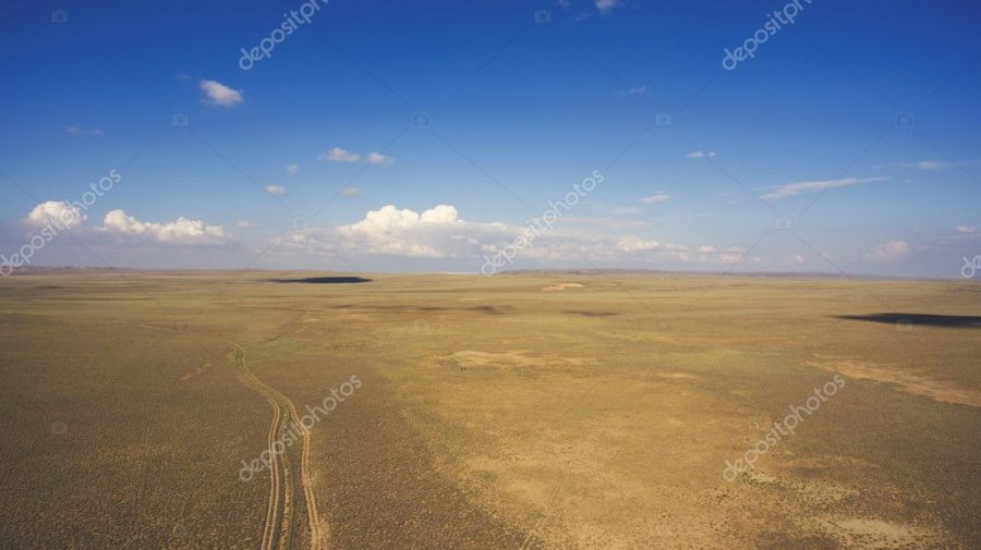 Top view aerial photo from drone of off road way with tires of car in arid dessert valley landscape.