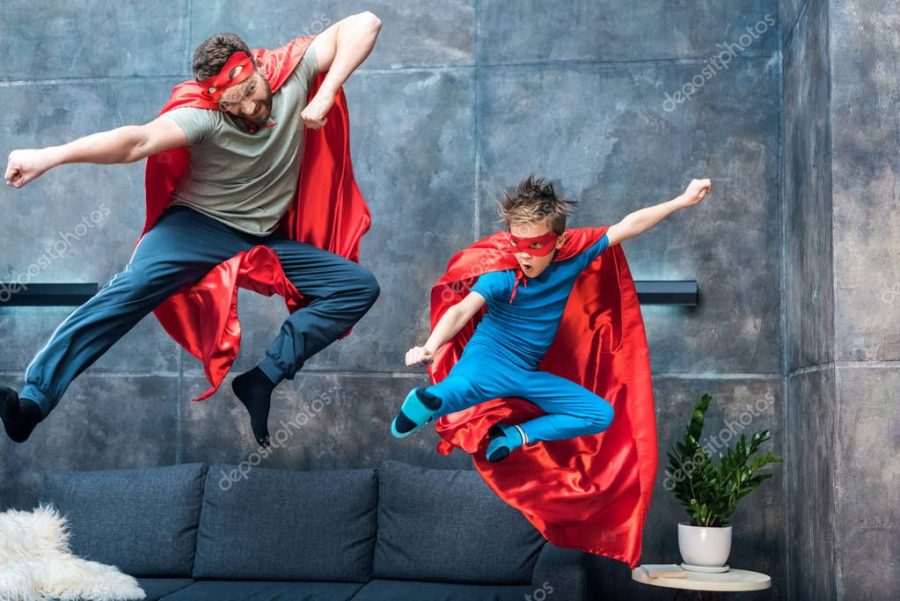 father and son in superhero costumes