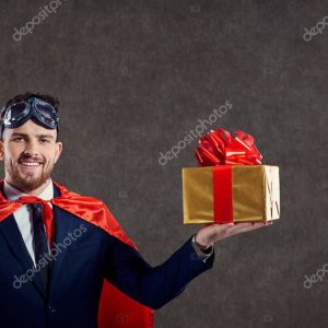 A man in a superhero costume with a gift box.