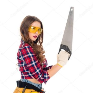 beautiful sexy girl in goggles with tool belt holding saw, isolated on white