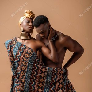 sexy naked tribal afro woman covered in blanket posing near man on beige