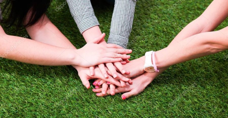 Group of friends joining hands. Unity, teamwork concept