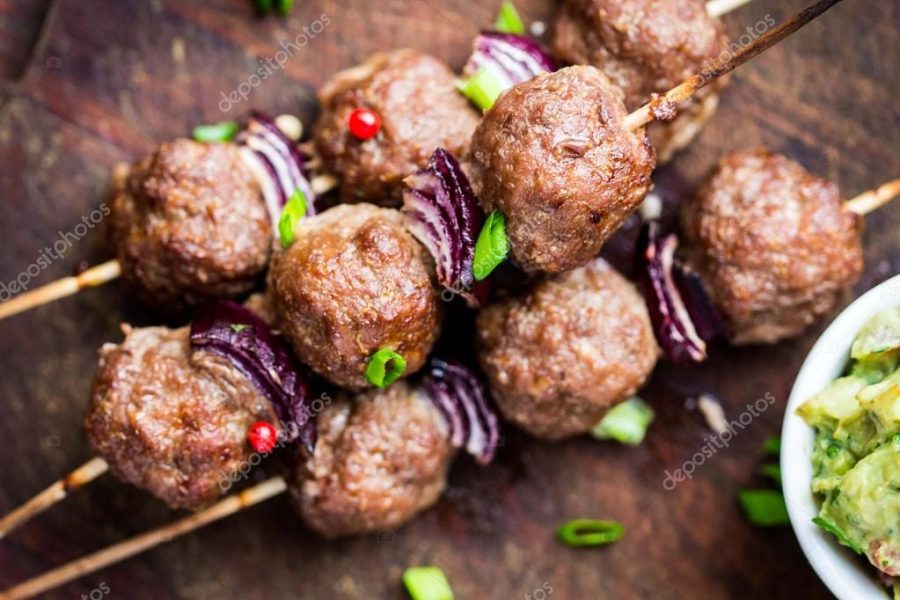 Meat kebab, beef balls on skewer with onions, sauce guacamole