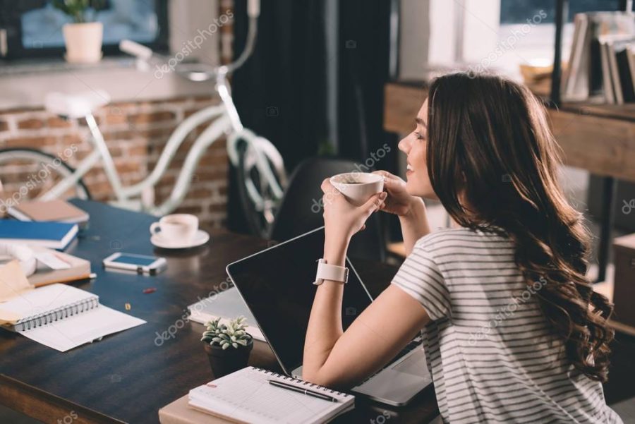 woman with laptop drinking coffee