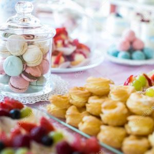 Table setting. Colorful macarons and cakes.