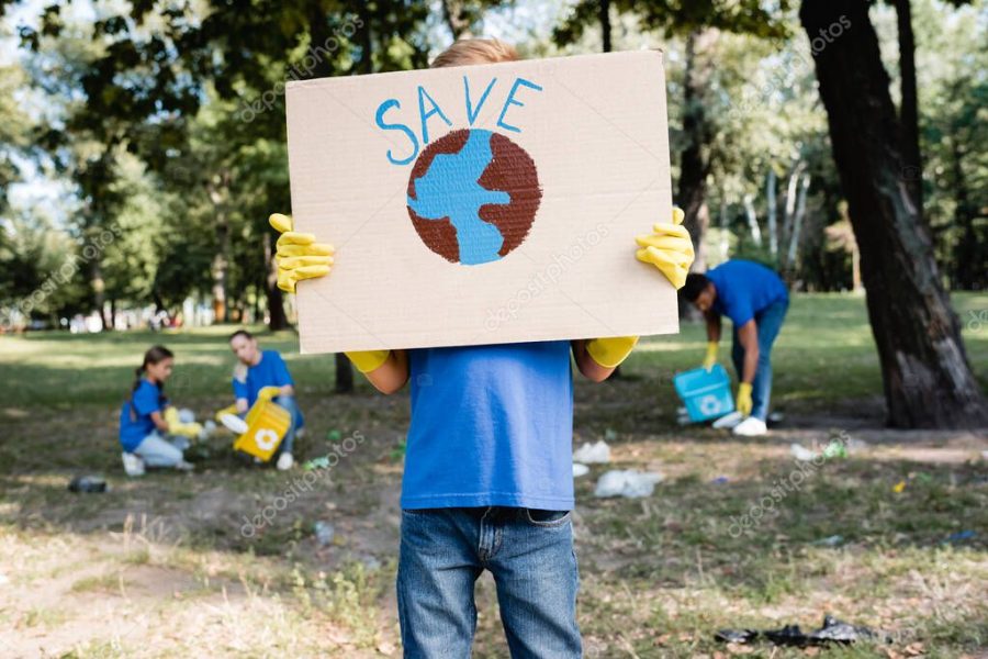 boy holding placard with globe and save inscription near family collecting rubbish in forest on blurred background, ecology concept