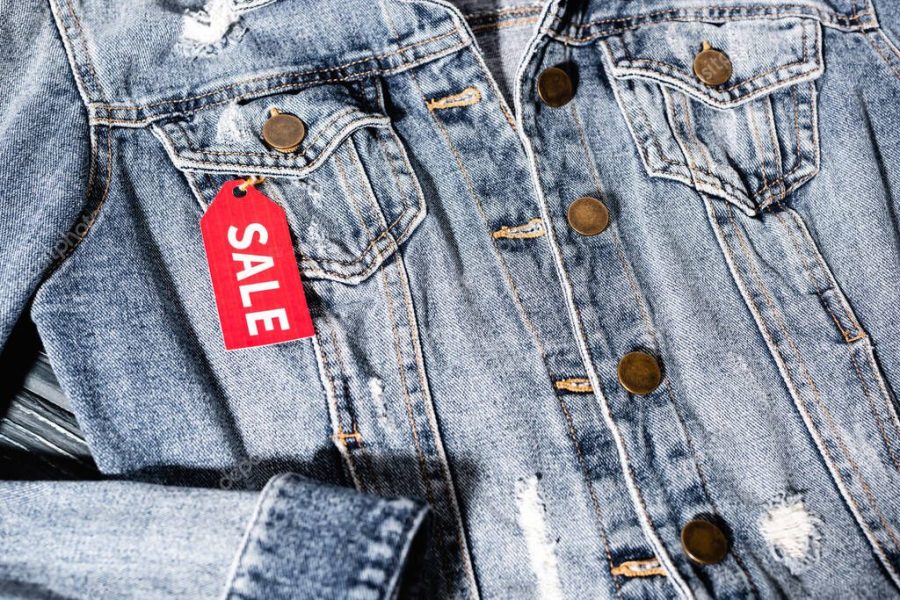 close up of red sale tag on blue denim jacket, black friday concept