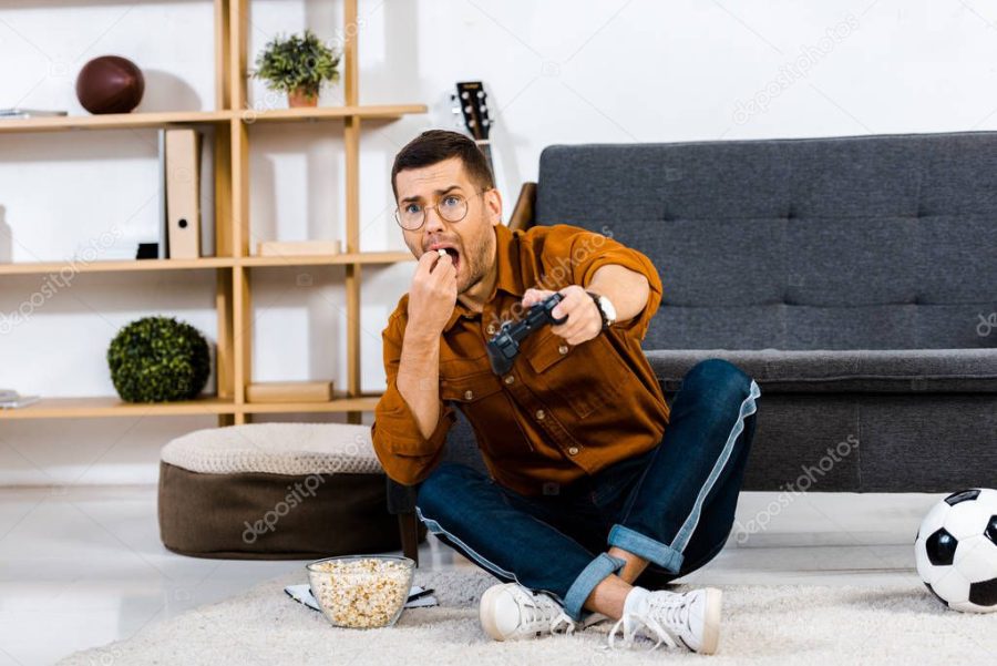 emotional man eating popcorn while playing video game