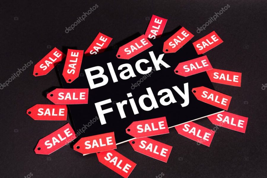 placard with black friday lettering near sale tags on dark background