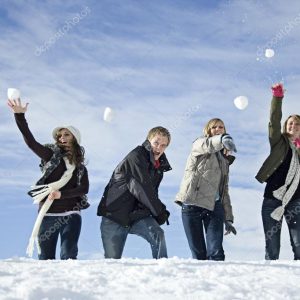 Young adults snowball fighting