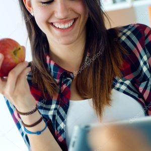 Beautiful young woman using her digital tablet at home.