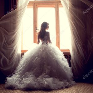 The beautiful bride against a window indoors