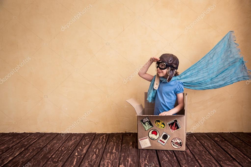 child playing in cardboard box